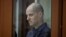 Wartawan Wall Street Journal Evan Gershkovich berada dalam bilik kaca dalam persidangan atas dakwaan spionase yang membelitnya di Yekaterinburg, Rusia, pada 26 Juni 2024. (Foto: Reuters/Evgenia Novozhenina)