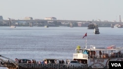 A ferry carrying passengers and cars in the Tonle Sap river on the first day of the annual Water Festival. The Cambodian government cancels boat racing again this year, claiming the rivers are “too shallow.” (Photo: Aun Chhengpor/VOA)