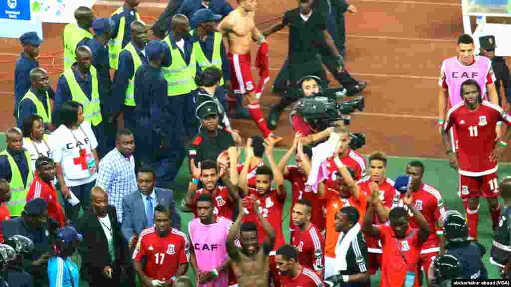 Jogadores guineenses são protegidos pela polícia enquanto saem do campo, após uma vitória controversa contra a Tunísia nos quartos de final da CAN 2015.