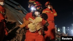 Tim SAR China menyelamatkan seorang anak dari reruntuhan bangunan Hotel Xinjia Express Quanzhou, provinsi Fujian, Minggu (8/3). 