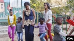 Premyè dam Michelle Obama ak pitit li Sasha ak Malia, k ap mache ak timoun nan zon nan pandan yon vizit nan yon sant kominotè Emthonjeni ki nan Johannesburg (AP Photo/Charles Dharapak, Pool)