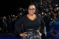 FILE - Oprah Winfrey poses for photographers at a premiere in London.