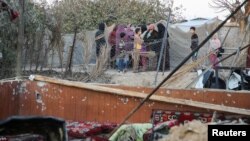 Palestinians inspect the damage at a tent camp sheltering displaced people, following an Israeli strike, amid the Israel-Hamas conflict, in the Al-Mawasi area in Khan Younis, southern Gaza Strip, Dec. 23, 2024.