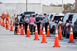 Florida Department of Health medical workers prepare to administer a COVID-19 vaccine to seniors in the parking lot of the Gulf View Square Mall in New Port Richey near Tampa, Florida, Dec. 31, 2020.