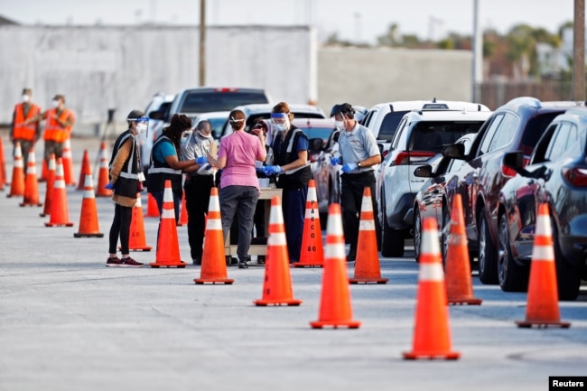 Florida Department of Health medical workers prepare to administer a COVID-19 vaccine to seniors in the parking lot of the Gulf View Square Mall in New Port Richey near Tampa, Florida, Dec. 31, 2020.