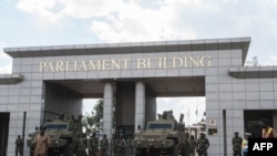 Des soldats des forces de défense du Malawi montent la garde avec des véhicules blindés à l'entrée du parlement malawite.