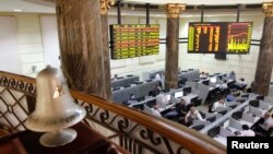 FILE - Traders work near the exchange bell at Egypt's Stock Exchange in Cairo, July 3, 2013. 