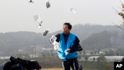 Park Sang-hak, pengungsi Korea Utara, yang menerbangkan balon-balon yang membawa pamflet propaganda anti-Korea Utara, sedang menyebarkan pamflet di sebuah jalan di Paju, dekat zona demiliterisasi, Korea Selatan, 22 Oktober 2012. (Foto: Ahn Young-joon/AP Photo)
