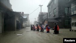 Tim penyelamat di jalanan yang terendam banjir di kota yang dilanda Topan Soudelor di Ningde, provinsi Fujian, China, 9 Agustus 2015. 