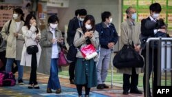 2020年4月6日戴着口罩的人群在东京等车。