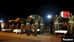 Les membres des Forces de Défense du Kenya portent les cercueils de leurs camarades qui servent dans la Mission de l'Union africaine en Somalie (AMISOM), qui ont été tués lors d'une attaque sur une base militaire dans l'ouest de la Somalie près de la frontière avec le Kenya par le groupe jihadiste el Shebab de la Somalie, 18 janvier 2016.