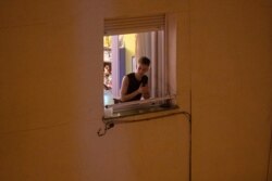 A man applauds from his window in support of the medical staff in Madrid, Spain, March 15, 2020.