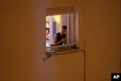 A man applauds from his window in support of the medical staff in Madrid, Spain, March 15, 2020.