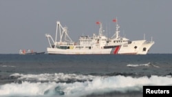 FILE - China Coast Guard vessels are pictured at the disputed Scarborough Shoal, in the South China Sea, April 5, 2017. 