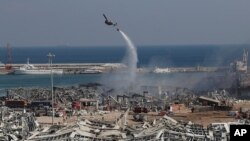 Un helicóptero del ejército libanés colabora en las tareas de extinción del incendio tras la explosión.