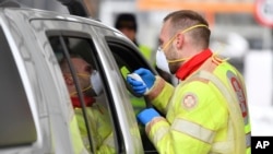 Petugas medis mengukur suhu tubuh penumpang di sebuah mobil di dekat Gries am Brenner, provinsi Tyrol Austria, perbatasan dengan Italia, 10 Maret 2020. (Foto: dok).