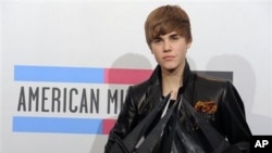 Justin Bieber hold his awards backstage at the 38th Annual American Music Awards on 21 Nov. 2010 in Los Angeles.