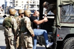 Lebanese army soldiers arrest an anti-government protester after scuffles broke out in the town of Zouk Mosbeh, north of Beirut, Lebanon, Nov. 5, 2019.