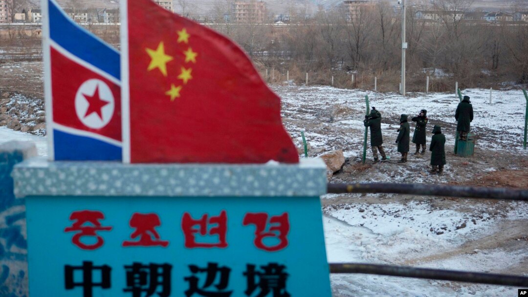 FILE - A Chinese-built fence near a concrete marker depicting the North Korean and Chinese national flags with the words "China North Korea Border" at a crossing in the Chinese border town of Tumen in eastern China's Jilin province. 