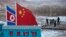 FILE - A Chinese-built fence near a concrete marker depicting the North Korean and Chinese national flags with the words "China North Korea Border" at a crossing in the Chinese border town of Tumen in eastern China's Jilin province. 