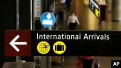 FILE - A sign for International Arrivals is shown at the Seattle-Tacoma International Airport in Seattle, June 26, 2017.