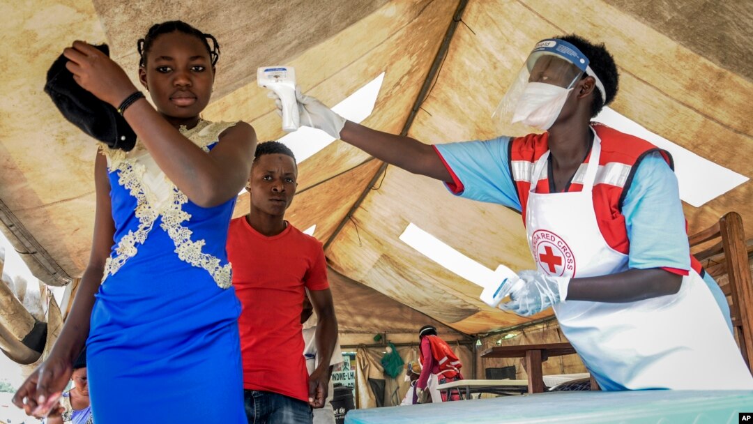 Petugas mengukur suhu tubuh seorang yang baru datang dari Kongo di perbatasan Uganda untuk mendeteksi kemungkinan terjangkit virus ebola, Jumat (14/6).