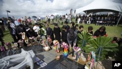 Family members from Japan place flowers at a memorial during a ceremony to commemorate the 10th anniversary of the sinking of the Ehime Maru, at the Ehime Maru Memorial in Honolulu, February 9, 2011.