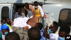 FILE - Health workers carry a wounded Tanzanian from a military helicopter at Jangwani grounds in Dar es Salaam, Tanzania, Aug. 11, 2019. 