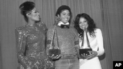 Michael Jackson is flanked by Singer Bonnie Pointer, left, and his sister Latoya, right, at the American Music Awards in Los Angeles, Jan. 31, 1981. Jackson won two awards for favorite soul album "Off the Wall" and favorite male soul vocalist.