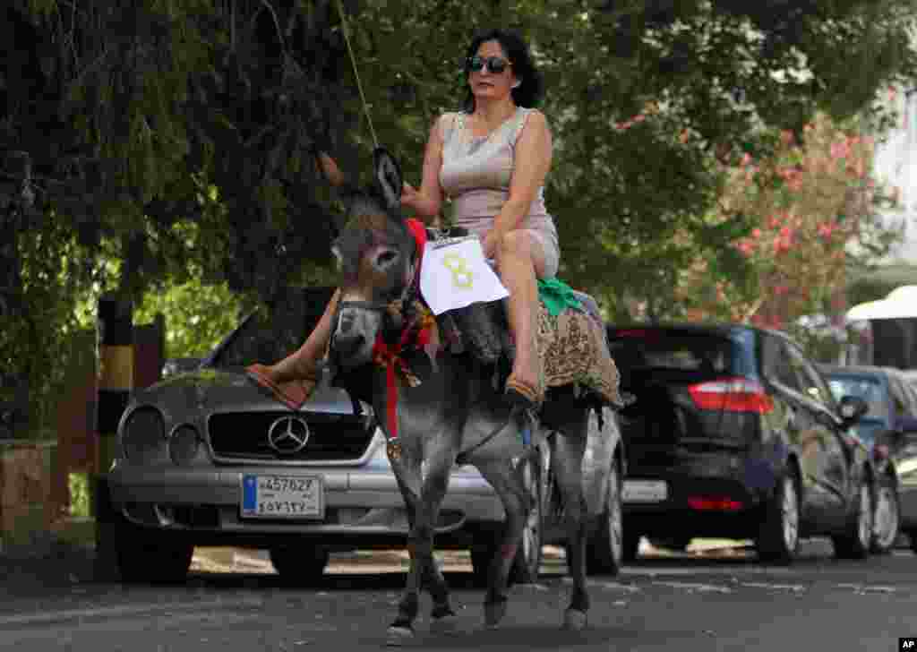 A Lebanese woman rides a donkey during an annual race competition in the southern Lebanese city of Jezzine, Aug. 9, 2015.