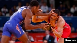 FILE - Jordan Ernest Burroughs of US (in blue) fights with Iran's Sadegh Saeed Goudarzi at the London Olympics, August 10, 2012