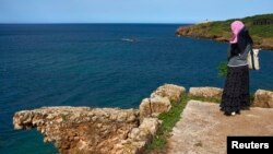 Une Algérienne regarde la mer en visitant une ruine romaine sur le site archéologique de Tipasa, classé au patrimoine mondial de l'UNESCO, à environ 70 km (43 miles) à l'ouest d'Alger, le 4 mai 2012. REUTERS / Zohra Bensemra 