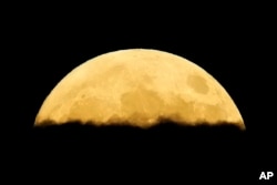 A supermoon rises behind clouds over Larnaca International Airport on the eastern Mediterranean island of Cyprus, Sept. 17, 2024.