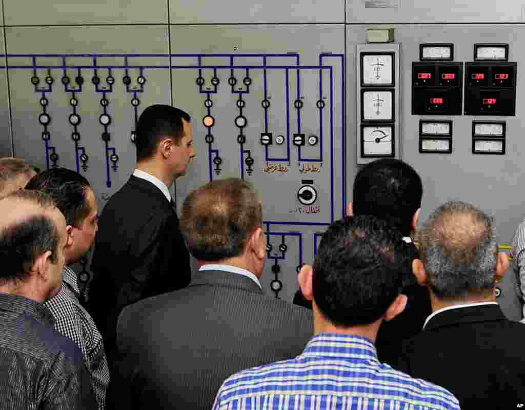 This photo released by the Syrian official news agency SANA shows Syrian President Bashar al-Assad visiting the Umayyad Electrical Station, Damascus, Syria, May 1, 2013. 