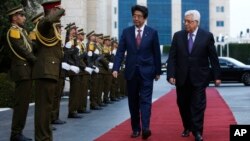 Perdana Menteri Jepang Shinzo Abe dan Presiden Palestina Mahmoud Abbas disambut barisan pasukan kehormatan untuk tamu negara, setibanya di kota Ramallah, Tepi Barat, Selasa, 1 Mei 2018. (AP Photo / Majdi Mohammed, Pool)