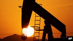 An oil pump works at sunset in the desert oil fields of Sakhir, Bahrain, in the Persian Gulf.