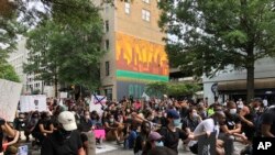 Protesters pause in a moment of silence during a march June 6, 2020, in downtown Atlanta. 