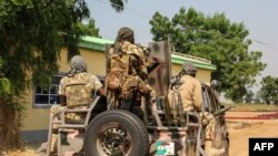 Des soldats de l'armée nigériane sont vus roulant sur un véhicule militaire à Ngamdu, au Nigeria, le 3 novembre 2020.