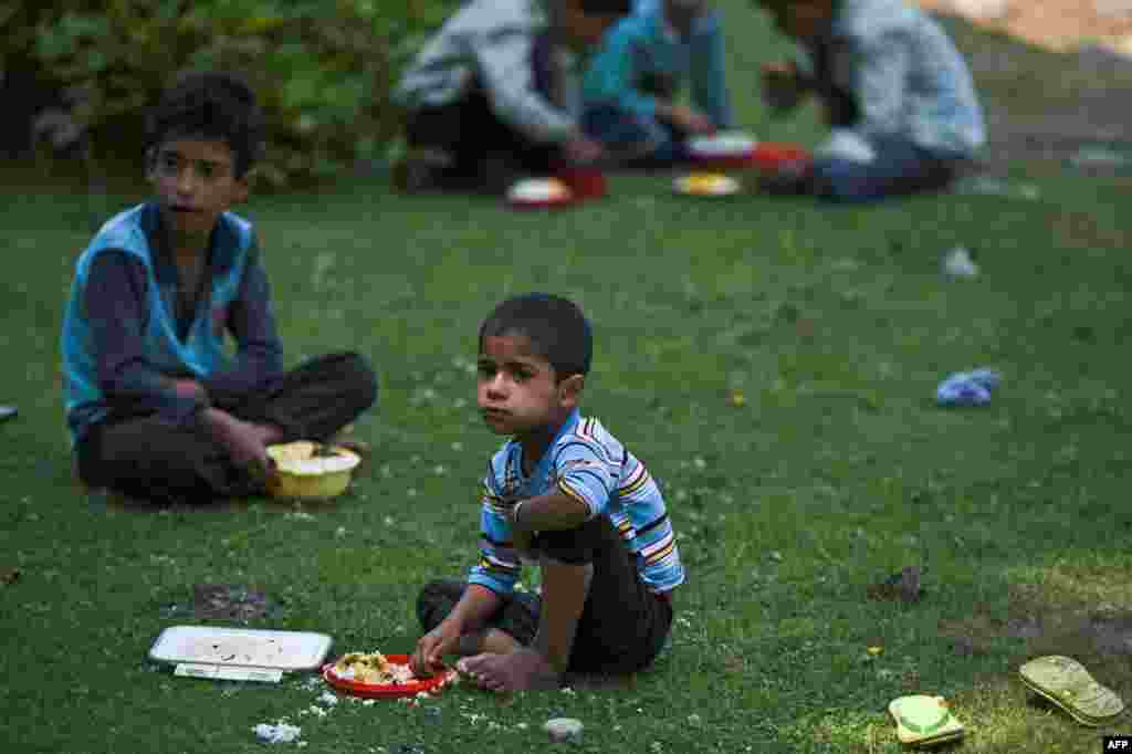 &#39;اوپن ایئر&#39; اسکول میں پڑھنے آنے والے بچے لنچ ٹائم میں کھانا کھا رہے ہیں۔