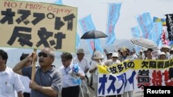 Warga Jepang berunjuk rasa menentang penggunaan pesawat MV-22 Osprey di sekitar pusat pangkalan udara AS di Iwakuni, wilayah Yamaguchi, Jepang barat (23/7).