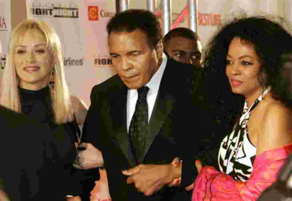 Muhammad Ali camina con la actriz Sharon Stone (izquierda) y la cantante Diana Ross.