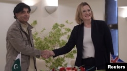 Pakistani Interior Minister Chaudhry Nisar Ali Khan (L) shakes hands with British Home Secretary Amber Rudd after an agreement signing on security issues in Islamabad, March 21, 2017. 