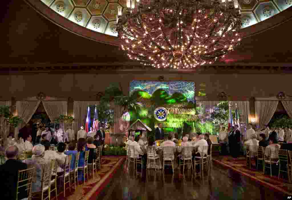 U.S. President Barack Obama, center, stands to speak as he attends a state dinner with Philippine President Benigno Aquino III at Malacanang Palace in Manila, Philippines, April 28, 2014.