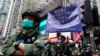 Seorang polisi memegang spanduk peringatan untuk para demonstran pada Hari Nasional China di Causeway Bay, Hong Kong, Kamis, 1 Oktober 2020. (AP Photo/Vincent Yu)