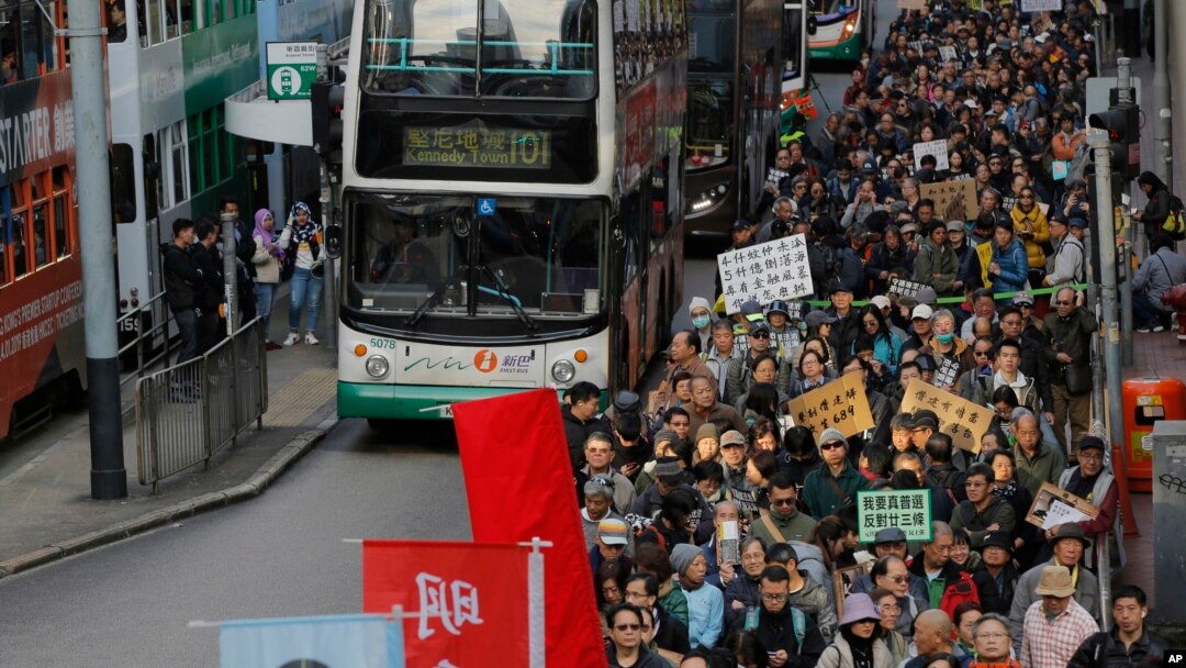 Riuan demonstran anti-pemerintah berpawai di jalan-jalan utama Hong Kong, 1 Januari 2019. 