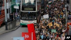 Riuan demonstran anti-pemerintah berpawai di jalan-jalan utama Hong Kong, 1 Januari 2019. 