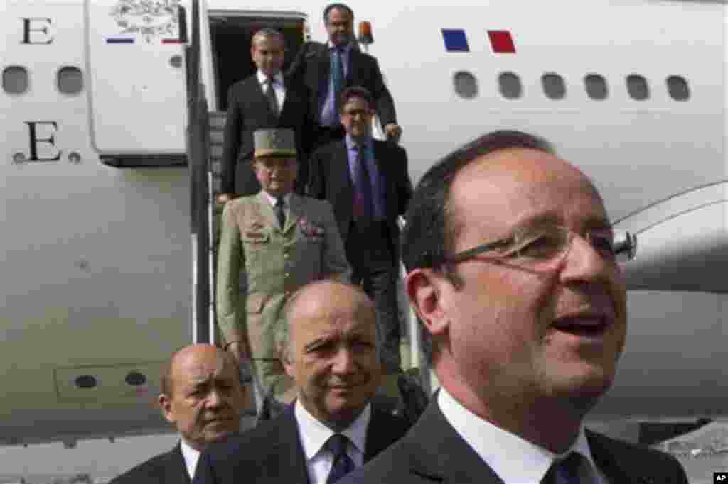 French President Francois Hollande followed by his Foreign Minister Laurent Fabius, center, and his Defense Minister Jean Yves Le Drian, left, arrive at Kabul airport, Friday, May 25, 2012, before visiting troops in the Kapisa region of Afghanistan. Franc