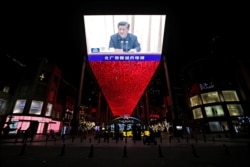 Giant screen shows CCTV state media broadcast of Chinese President Xi Jinping, at a shopping complex in Beijing, March 2, 2021.