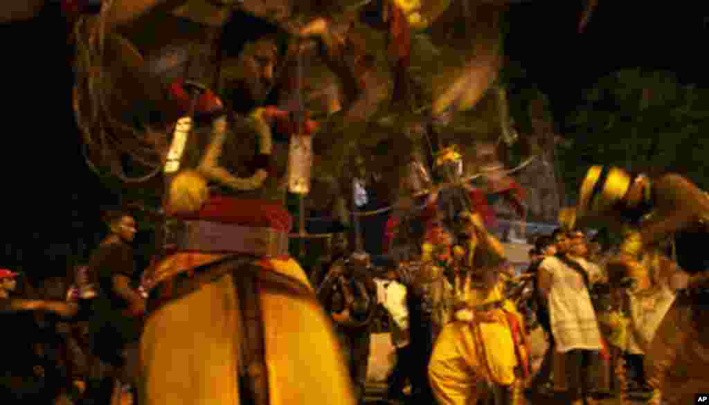 Devotees carry burdens, known as kavadis, as offerings of sacrifices to Lord Murugan. On the way to the temple, some devotees claim to be filled with the spirit of the deity and would dance as they journeyed to the temple. (VOA - Yong YN)