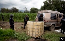 State police seize an abandoned truck that was used to carry stolen gasoline in plastic tanks, near an illegal tap into a state-owned pipeline in the middle of a cornfield in San Bartolome Hueyapan, Tepeaca, Mexico, July 11, 2017.